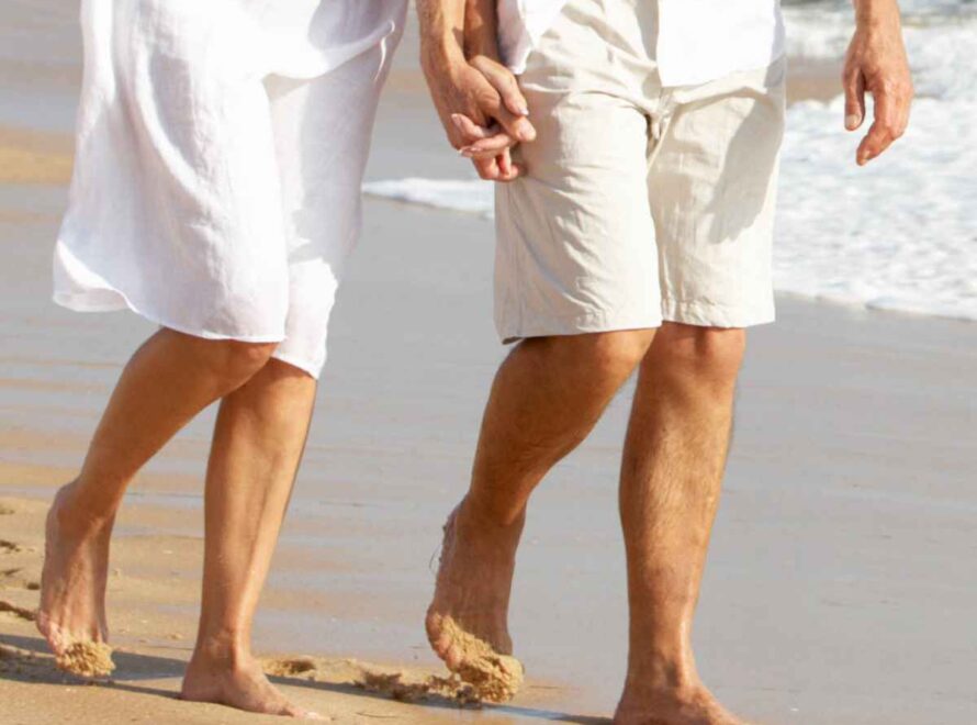 man and woman walking on the beach