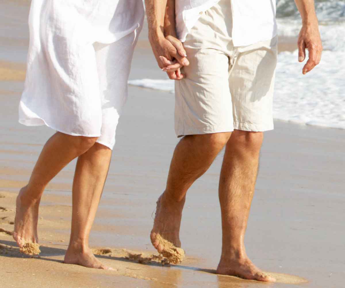 man and woman walking on the beach