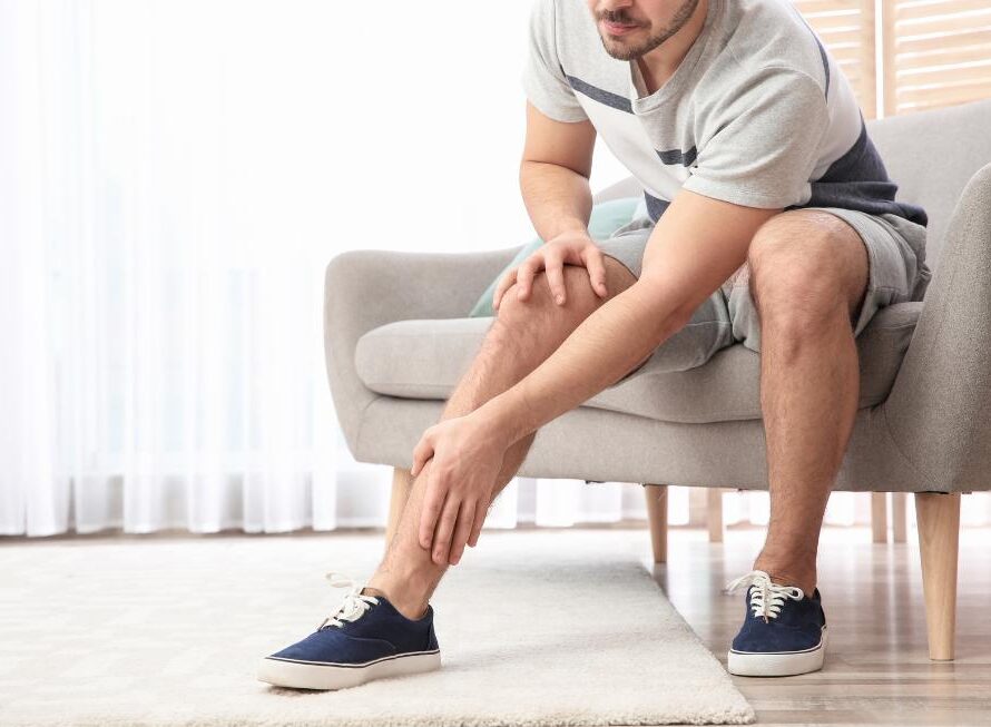 man holding leg sitting on chair